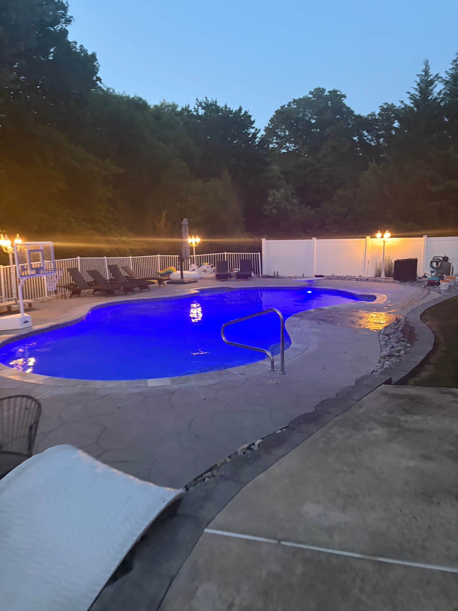 Spa Electrics LED pool light — deep blue at dusk, flagstone deck