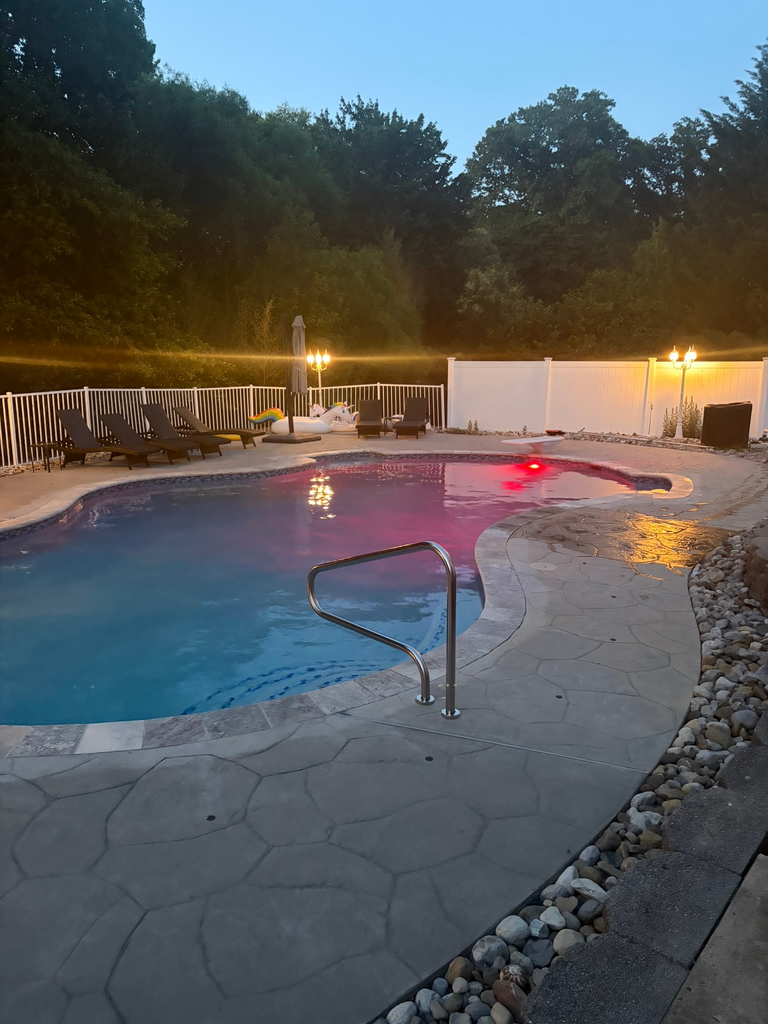 Spa Electrics LED pool light — red at dusk, flagstone deck